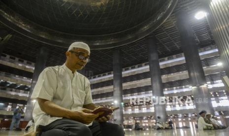 Sejumlah umat Islam membaca Al Quran sambil menunggu waktu pelaksanaan Shalat Dzuhur berjamaah di Masjid Istiqlal, Jakarta, Jumat (20/3). Masjid Istiqlal tidak menggelar Shalat Jumat sesuai kebijakan Majelis Ulama Indonesia (MUI), Pemerintah Pusat dan daerah untuk mengurangi penyebaran Corona atau Covid-19, namun menggelar Shalat Zuhur berjamaah. Putra M. Akbar/Republika