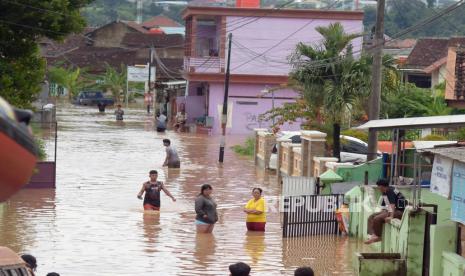 Sejumlah warga melintasi genangan air saat banjir melanda Kelurahan Kota Karang, Teluk Betung Timur, Bandar Lampung, Lampung, Jumat (12/4/2024). Banjir tersebut terjadi akibat curah hujan yang tinggi yang mengakibatkan debit air di Sungai Way Belau meningkat dan merendam ratusan rumah penduduk setempat. 