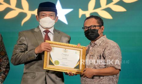 Ketua Badan Amil Zakat Nasional (BAZNAS) RI KH. Noor Achmad memberikan pengahargaan kepada Wakil Pemimpin Redaksi Republika Nur Hasan Murtiaji dalam acara Baznas Award 2022 di Jakarta, Senin (17/1/2022). Republika mendapatkan pengargaan Baznas Award 2022 Ketegori Media Pendukung Gerakan Zakat Indonesia pada Media Cetak.Prayogi/Republika