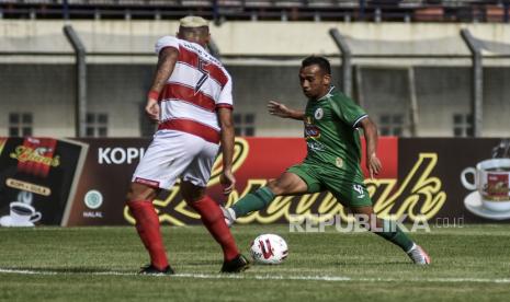 Penyerang PSS Sleman Irfan Jaya (kanan) diadang bek Madura United Jaime Xavier (kiri) dalam pertandingan babak penyisihan Grup C Piala Menpora 2021 di Stadion Si Jalak Harupat, Kabupaten Bandung, Selasa (23/3). Dalam pertandingan tersebut Madura United mengalahkan PSS Sleman dengan Skor 2-1. Foto: Republika/Abdan Syakura