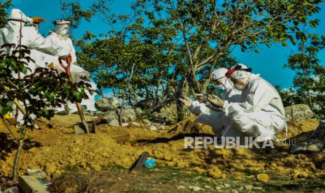 Sejumlah petugas mendoakan seorang Pasien Dalam Pengawasan (PDP) COVID-19 yang baru saja dimakamkan di Tempat Pemakaman Umum (TPU) Poboya, Palu, Sulawesi Tengah, Senin (11/5/2020). PDP berusia 56 tahun itu meninggal dunia dalam perawatan di Rumah Sakit Undata Palu