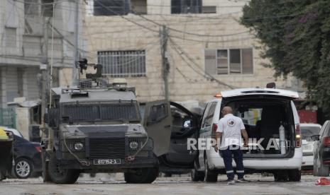 Anggota pasukan Israel di dalam kendaraan lapis baja memeriksa ambulans  saat operasi militer di kota Jenin, Tepi Barat, Rabu (28/8/2024). Bentrokan dengan militer Israel di Tepi Barat meningkat tajam sejak dimulainya perang Israel-Hamas di Gaza.