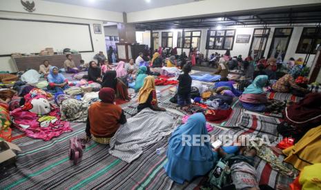 Sejumlah warga terdampak abu vulkanik dari awan panas guguran (APG) Gunung Semeru mengungsi di Kantor Kecamatan Candipuro, Lumajang, Jawa Timur, Ahad (4/12/2022). Menurut data Pusat Pengendali dan Operasi (Pusdalops) Badan Nasional Penanggulangan Bencana (BNPB) ada 1.979 jiwa mengungsi di 11 titik pengungsian. 