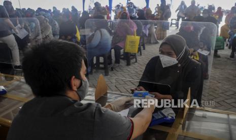 Petugas memberikan Kartu ATM Bank DKI dan buku rekening untuk orang tua dari anak penerima Kartu Jakarta Pintar (KJP) saat penyaluran KJP Plus tahap dua di kawasan Matraman, Jakarta Timur, Rabu (24/11/2021). 