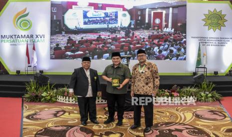 Ketua Umum PP Persatuan Islam KH Aceng Zakaria (kiri) berfoto dengan Menteri BUMN Erick Thohir (tengah) usai memberikan cinderamata pada Muktamar XVI Persatuan Islam (Persis) di Soreang, Kabupaten Bandung, Sabtu (24/9/2022). Pada kesempatan tersebut Menteri BUMN Erick Thohir menyampaikan orasi kebangsaan dengan tema Langkah-langkah Strategis Penguatan Ekonomi Umat Untuk Indonesia Maju dan Berdikari. Republika/Abdan Syakura