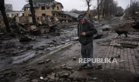 Konstyantyn, 70, merokok di tengah tank Rusia yang hancur di Bucha, di pinggiran Kyiv, Ukraina, Ahad, 3 April 2022.