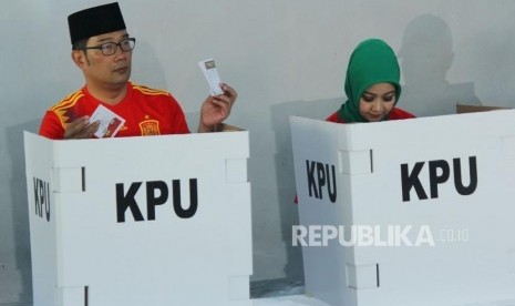 Calon Gubernur Jawa Barat Ridwan Kamil bersama istri Atalia Praratya melakukan pencoblosan dalam Pilkada Serentak 2018, di rumahnya, di Cigadung, Kota Bandung, Rabu (27/6).