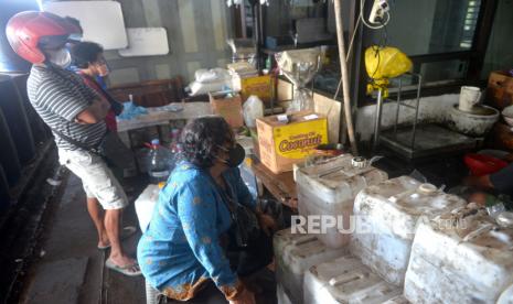 Pedagang antre membeli minyak goreng curah di agen minyak goreng, Yogyakarta, Kamis (17/3/2022). Harga minyak goreng curah untuk tingkat agen di Yogyakarta dijual dengan harga Rp 14 ribu per kilogram. Harga ini mengacu dengan aturan Pemerintah terbaru untuk minyak goreng curah. Adanya perubahan peraturan ini pedagang dan UMKM memburu minyak goreng curah karena harganya masih terjangkau.