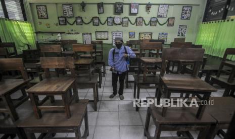 Petugas menyemprotkan cairan disinfektan di SDN 03 Kota Bambu, Tanah Abang, Jakarta, Jumat (20/11). Kementerian Pendidikan dan Kebudayaan mengizinkan pemerintah daerah untuk memutuskan pembukaan sekolah atau kegiatan belajar tatap muka di seluruh zona risiko virus Corona mulai Januari 2021. Republika/Putra M. Akbar