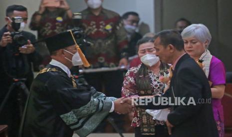 Ayah dari almarhum Brigadir Nopriyansyah Yosua Hutabarat atau Brigadir J, Samuel Hutabarat (kanan) didampingi istri Rosti Simajuntak (ketiga kanan) menerima ucapan selamat atas kelulusan anaknya dari Rektor Universitas Terbuka Ojat Darojat (kiri) saat acara prosesi wisuda di Kampus Universitas Terbuka Pondok Cabe, Tangerang Selatan, Banten, Selasa (23/8/2022). Almarhum Brigadir Yosua diwisuda bersama 2499 mahasiswa lainnya sebagai Sarjana Ilmu Hukum oleh Universitas Terbuka. 