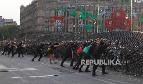  Demonstran merobohkan pagar keamanan dalam aksi protes menentang kekerasan seksis, di Mexico City, Meksiko, 25 November 2020. Protes tersebut bertepatan dengan Hari Internasional Penghapusan Kekerasan terhadap Perempuan.