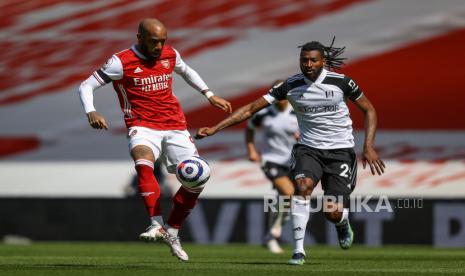  Alexandre Lacazette (kiri) dari Arsenal beraksi melawan Andre-Frank Zambo Anguissa (kanan) dari Fulham selama pertandingan sepak bola Liga Utama Inggris antara Arsenal FC dan Fulham FC di London, Inggris, 18 April 2021.