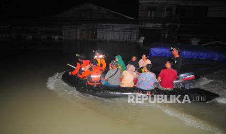 Relawan gabungan mengevakuasi warga dengan perahu karet akibat terjebak banjir di Karanganyar, Demak, Jawa Tengah, Jumat (9/2/2024). Hingga Jumat (9/2) dini hari relawan gabungan masih mengevakuasi ratusan warga yang terjebak banjir, sementara BPBD Kabupaten Demak hingga Kamis (8/2) malam mendata 30 desa di tujuh kecamatan terendam banjir sejak Senin (5/2) akibat jebolnya tanggul Sungai Jratun, Sungai Wulan, Sungai Tuntang, dan Sungai Cabean dampak dari hujan deras dari wilayah hulu. 