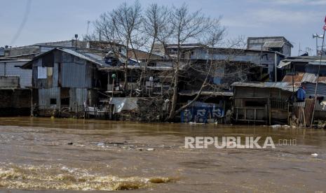 Seorang warga beraktivitas di dekat Sungai Ciliwung yang meluap (ilustrasi)