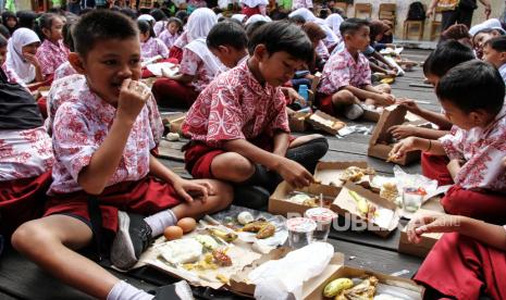 Sejumlah pelajar menyantap makanan bergizi gratis saat giat makan sehat bersama di SDN 7 Pahandut, Palangka Raya, Kalimantan Tengah, Kamis (3/10/2024).