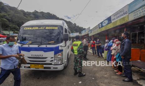 Petugas gabungan menurunkan penumpang angkutan umum antarkota untuk mengecek identitas dan memberikan imbauan kepada warga di titik pemeriksaan perbatasan Cianjur - Bogor, Jalan Raya Puncak, Kabupaten Cianjur, Jawa Barat, Kamis (21/5/2020). Petugas gabungan memperketat akses keluar masuk kendaraan yang melewati perbatasan dalam pemberlakuan Pembatasan Sosial Berskala Besar (PSBB) di Cianjur Jawa Barat