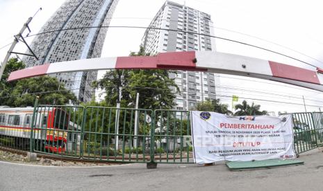 Sebuah Kereta Rel Listrik (KRL) Comutter Line melintas pada perlintasan sebidang yang sudah ditutup di kawasan Stasiun Palmerah, Jakarta, Ahad (29/11/2020). Dinas Perhubungan DKI Jakarta resmi menutup perlintasan sebidang kereta api tersebut terkait adanya program penataan tahap dua di Stasiun Palmerah. 