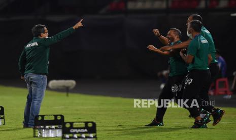 Pelatih Persebaya Surabaya Aji Santoso (kiri) berselebrasi dengan anggota ofisial setelah timnya berhasil memetik kemenangan di Liga 1 2022/2023.