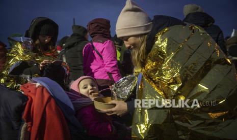 Seorang wanita memberi makan putrinya setelah melarikan diri dari Ukraina dan tiba di perbatasan di Medyka, Polandia, Senin, 7 Maret 2022.