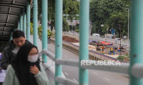 Pekerja berjalan di jembatan penyeberangan (ilustrasi). Kepala BKPM menyebut kenaikan upah minimum diharapkan menaikkan produktivitas.