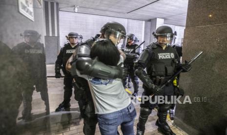 Seorang demonstran memeluk seorang polisi ketika aksi menentang kematian George Floyd dan Breonna Taylor setelah pengunjuk rasa meneriakkan, 