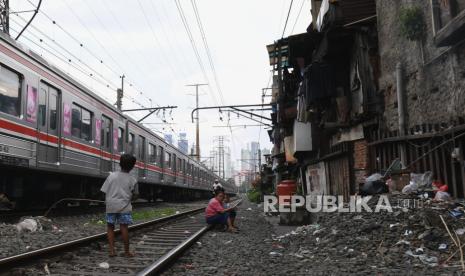 Anak-anak bermain di rel kereta api di api di kawasan Pejompongan, Jakarta, Jumat (15/7/2022). Badan Pusat Statistik (BPS) mencatat jumlah penduduk miskin di Indonesia pada Maret 2022 berjumlah 26,16 juta orang atau menurun 1,38 juta orang (0,60 persen) dibandingkan Maret 2021. 