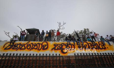 Orang-orang melihat-lihat di taman kediaman perdana menteri di Kolombo, Sri Lanka, 11 Juli 2022, dua hari setelah kediaman resmi diserbu. Presiden dan perdana menteri Sri Lanka setuju untuk mengundurkan diri setelah pertemuan para pemimpin partai selama hari protes anti-pemerintah besar-besaran. Ribuan pengunjuk rasa pada 09 Juli menerobos barikade polisi dan menyerbu istana Presiden, sekretariat Presiden, dan kediaman resmi perdana menteri. Protes telah mengguncang negara itu selama berbulan-bulan, menyerukan pengunduran diri presiden dan perdana menteri atas dugaan kegagalan mengatasi krisis ekonomi terburuk dalam beberapa dekade.