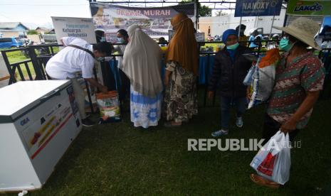 Warga antre saat berbelanja berbagai kebutuhan pada gelaran pasar murah. 