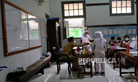 Siswa mengikuti pembelajaran tatap muka (PTM) di SDN Lempuyangwangi, Yogyakarta, Senin (17/1/2022). Pemerintah Kota Yogyakarta hingga kini belum menerapkan PTM 100 persen karena menunggu evaluasi PTM 70 persen. Rencananya PTM 100 persen akan diberlakukan pada 24 Januari mendatang.