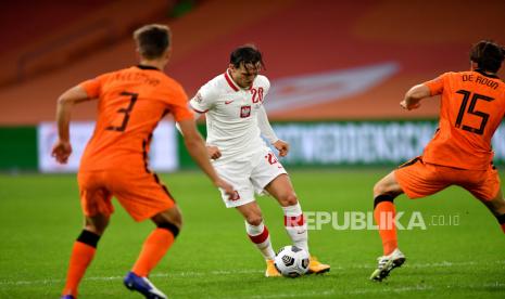  Joel Veltman (Kiri) dan Marten de Roon (Kanan) dari Belanda beraksi melawan Piotr Zielinski (tengah) dari Polandia selama pertandingan UEFA Nations League antara Belanda dan Polandia di Amsterdam, Belanda, 04 September 2020.