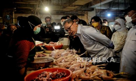 Menteri Perdagangan Zulkifli Hasan (kanan) berbincang bersama pedagang daging ayam.