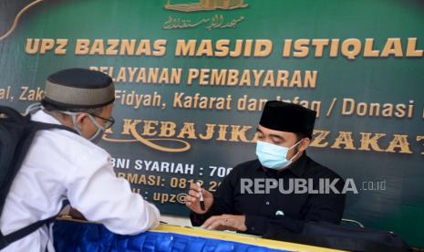 Orang-Orang yang Wajib Bayar Fidyah Puasa Ramadhan. Foto ilustrasi: Petugas Amil Zakat memberikan informasi kepada warga yang hendak membayar Zakat di Stand Pelayanan Zakat Masjid Istiqlal, Jakarta, Selasa (12/5). Di tengah Pamdemi Covid-19 UPZ Baznas Masjid Istiqlal tetap membuka pelayanan pembayaran Zakat Mal, Zakat Fitrah, Fidyah dan Infaq dengan memberikan dua pilihan pembayaran yaitu dengan cara datang langsung serta dengan cara transfer ke rekening yang ditetapkan