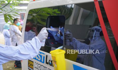 Petugas medis menyemprotkan cairan disinfektan pada peralatan dan jendela bilik pengambilan sampel lendir hidung dan tenggorokan mobil tes PCR keliling di Tulungagung, Jawa Timur, Jumat (29/5/2020). Lebih dari 200 orang yang terdiri dari tenaga medis di RSUD dr Iskak Tulungagung dan tiga puskesmas penyangga COVID-19, serta pasien berstatus PDP yang dkarantina di Rusunawa IAIN Tulungagung, diperiksa sampel lendir tenggorokannya untuk mendeteksi infeksi virus Corona atau SARS-Cov-2