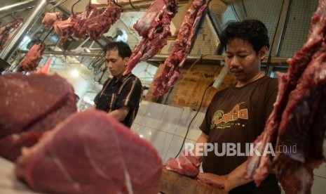 Harga Masih Tinggi. Pedagang daging sapi melayani pembali di pasar tradisional, Jakarta, Ahad (24/6).