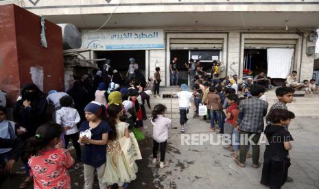 Warga Yaman menunggu bantuan makanan keluarga mereka untuk berbuka puasa, makanan yang secara tradisional diambil setelah salat magrib untuk berbuka puasa harian Ramadhan, selama bulan puasa Ramadhan di Sana