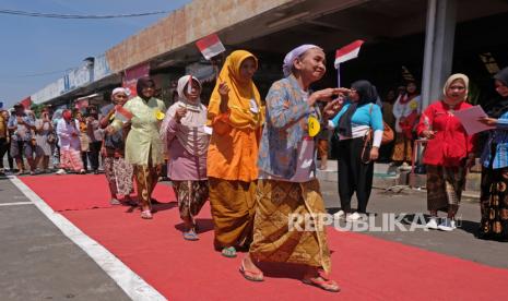 Buruh gendong berjalan di atas catwalk saat fashion show di kompleks pasar Rejowinangun, Magelang, Jateng, Selasa (15/8/2023). Fashion show dengan peserta para buruh gendong yang diselenggarakan oleh Kebaya Foundation dan pengelola pasar tradisional tersebut untuk memeriahkan HUT ke-78 Kemerdekaan RI. 