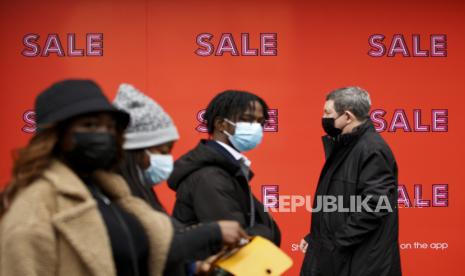  Pembeli yang mengenakan masker wajah untuk berjaga-jaga terhadap COVID-19 berjalan melewati poster penjualan yang menutupi jendela department store Selfridges di Oxford Street di London, Senin, 27 Desember 2021. Di Inggris, di mana varian omicron telah dominan selama berhari-hari, pemerintah persyaratan sebagian besar bersifat sukarela dan lebih ringan daripada yang ada di benua itu, tetapi pemerintah Konservatif mengatakan dapat memberlakukan pembatasan baru setelah Natal.