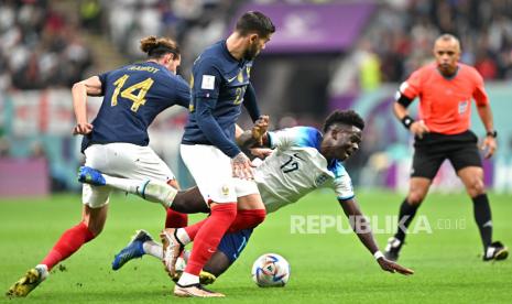 Bukayo Saka (Tengah) dari Inggris beraksi melawan Adrien Rabiot (kiri) dari Prancis selama pertandingan sepak bola perempat final Piala Dunia FIFA 2022 antara Inggris dan Prancis di Stadion Al Bayt di Al Khor, Qatar, 10 Desember 2022.