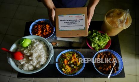 Hadjiah (54) pemilik UMKM Dapoer Mpok Iyah mengemas nasi box pesanan di rumahnya di kawasan Cakung, Jakarta Timur, Selasa (20/2/2024). UMKM Dapoer Mpok Iyah merupakan UMKM binaan PT Jakarta Industrial Estate Pulogadung (PT JIEP) yang menjual beragam jenis makanan seperti camilan stik bawang, nasi kebuli hingga melayani jasa catering. Pembinaan yang dilakukan PT JIEP berbuah hasil bagi usahanya, selain mendapatkan bantuan modal Ia juga mendapatkan pendampingan sertifikasi halal sehingga berdampak pada peningkatan omset hingga 50 persen dari Rp500 ribu per hari, kini Rp1 juta per hari.