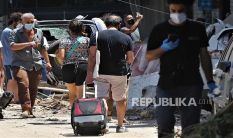  Orang-orang berjalan dengan barang-barang mereka setelah evakuasi dari perumahan mereka yang rusak di daerah Mar Mikhael dan Gemayzeh setelah ledakan besar menghancurkan pelabuhan di Beirut pada tanggal 4 Agustus 2020, di Beirut, Lebanon, 05 Agustus 2020. Menurut laporan media, setidaknya 100 orang terbunuh dan lebih dari 4.000 terluka setelah ledakan, yang disebabkan oleh lebih dari 2.500 ton amonium nitrat yang disimpan di sebuah gudang, menghancurkan area pelabuhan pada tanggal 4 Agustus. 