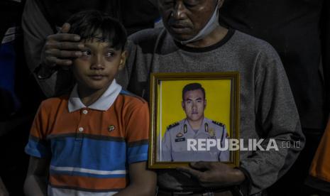 Keluarga jenazah almarhum Aiptu Anumerta Sofyan mengikuti prosesi pemakaman di pemakaman keluarga di Jalan Sukahaji, Kecamatan Sukasari, Kota Bandung, Rabu (7/12/2022). Aiptu Anumerta Sofyan merupakan korban meninggal dunia dalam peristiwa ledakan bom bunuh diri di Polsek Astana Anyar, Kota Bandung. 