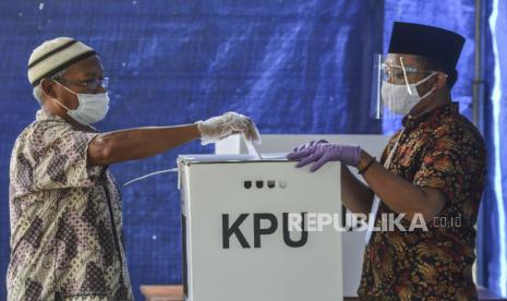 Warga dengan sarung tangan plastik sekali pakai di tangannya memasukan surat suara ke dalam kotak suara di TPS 02, Desa Pananjung, Kabupaten Pangandaran, Jawa Barat, Rabu (9/12/2020). Badan Pengawas Pemilihan Umum (Bawaslu) meminta jajarannya mengawasi pembuangan alat pelindung diri (APD) yang digunakan Kelompok Penyelenggara Pemungutan Suara (KPPS) dalam pelaksanaan pemungutan suara di tengah pandemi COVID-19 yang digelar serentak di 298.939 TPS dan 270 daerah. 