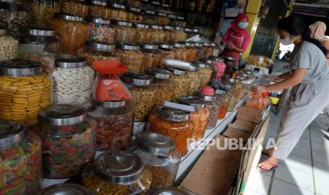 Pemulihan Ekonomi RI 2021 Masih akan Berliku dan Terjang. Pekerja merapikan stoples berisi kue kering yang dijual di Pasar Petisah, Medan, Sumatera Utara, Rabu (23/12/2020). Penjualan kue kering seharga Rp.30.000-Rp.150.000/Kg tersebut meningkat 30 persen dari bulan-bulan sebelumnya, karena kebutuhan masyarakat untuk perayaan Natal dan tahun baru. 