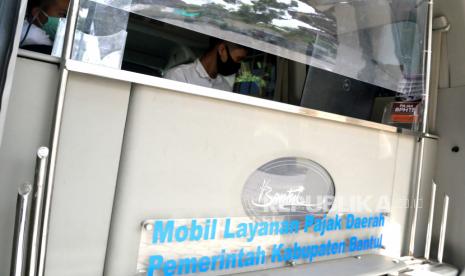 Petugas melayani warga membayar pajak bumi dan bangunan (PBB) melalui mobil keliling pajak Bantul di Kalurahan Panggungharjo, Bantul, Yogyakarta, Rabu (30/9). Kementerian Keuangan (Kemenkeu) menilai, tantangan yang dihadapi pemerintah dalam mengumpulkan penerimaan perpajakan Indonesia akan berat dalam jangka menengah. Hal ini tergambarkan dari rasio pajak yang diproyeksikan masih berada pada level single digit hingga 2024. 