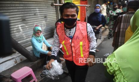 Seorang warga yang terjaring razia penindakan pelanggaran aturan Pembatasan Sosial Berskala Besar (PSBB) oleh Satpol PP menjalani hukuman dengan cara membersihkan sampah di Tanah Abang, Jakarta, Rabu (13/5/2020). Pemprov DKI Jakarta mulai memberlakukan sanksi sosial terhadap pelanggar PSBB yaitu dengan memakaikan rompi bertuliskan pelanggar PSBB saat mereka membersihkan fasilitas umum