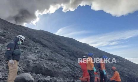 Dalam foto tak bertanggal yang dirilis 5 Desember 2023, oleh Badan Pencarian dan Pertolongan Nasional Indonesia (BASARNAS), tim penyelamat bersiap mengevakuasi jenazah seorang pendaki yang tewas dalam letusan Gunung Marapi di Agam, Sumatera Barat, Indonesia. Tim penyelamat yang mencari di lereng berbahaya gunung berapi Marapi di Indonesia menemukan lebih banyak mayat di antara para pendaki yang terkena letusan mendadak dua hari lalu.