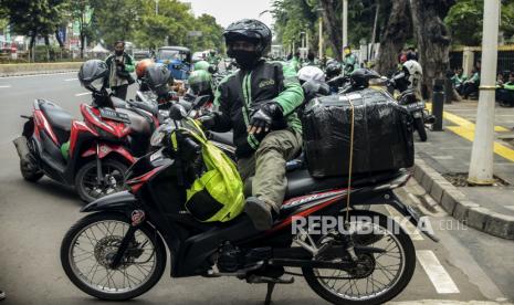 Sejumlah pengemudi ojek online membawa barang pesanan di Jalan Kramat Raya, Senen, Jakarta, Senin (13/4). Masih belum jelasnya regulasi antara Peraturan Menteri Perhubungan dan Peraturan Menteri Kesehatan terkait diperbolehkanya ojek online membawa penumpang selama masa Pembatasan Sosial Berskala Besar (PSBB) membuat pengemudi ojek online hanya bisa membawa barang pesanan selama masa pandemi COVID-19