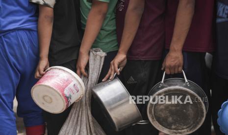 Warga Palestina antre untuk pembagian makanan di Deir al Balah, Gaza, Jumat, 10 Mei 2024.