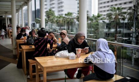 Pengunjung menyantap makanan di Festival Tjemilan TiJe di Halte TransJajarta Bundaran Hotel Indonesia, Jakarta Pusat, Sabtu (25/2/2023). Festival tersebut menyediakan beragam jajanan jadul serta makanan yang digelar mulai tanggal 23 Februari hingga 19 Maret sebagai upaya memberdayakan UMKM dengan memanfaatkan ruang publik sebagai sarana untuk berdagang.