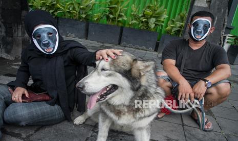 Relawan komunitas pecinta hewan melakukan aksi diam dengan topeng anjing di Solo, Jawa Tengah, Rabu (27/10/2021). Aksi tersebut sebagai bentuk solidaritas dan peryataan sikap keprihatinan atas dugaan penganiayaan yang dilakukan oknum Satpol PP terhadap seekor anjing bernama Canon di Pulau Banyak, Aceh. 